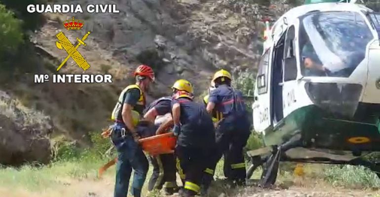 Momento en el que el equipo de rescate de la Guardia Civil mete al senderista en el helicóptero.