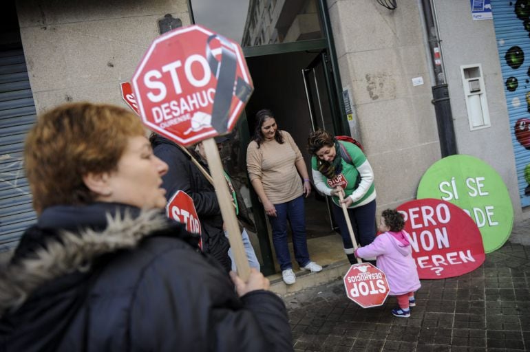 María del Pilar López (3d) y su hija Carolina (d), junto a activistas del colectivo Stop Desahucios en el exterior de su casa de la Calle de As Caldas en Ourense, después de que la plataforma consiguiese frenar, al menos una semana, el desalojo de su fami