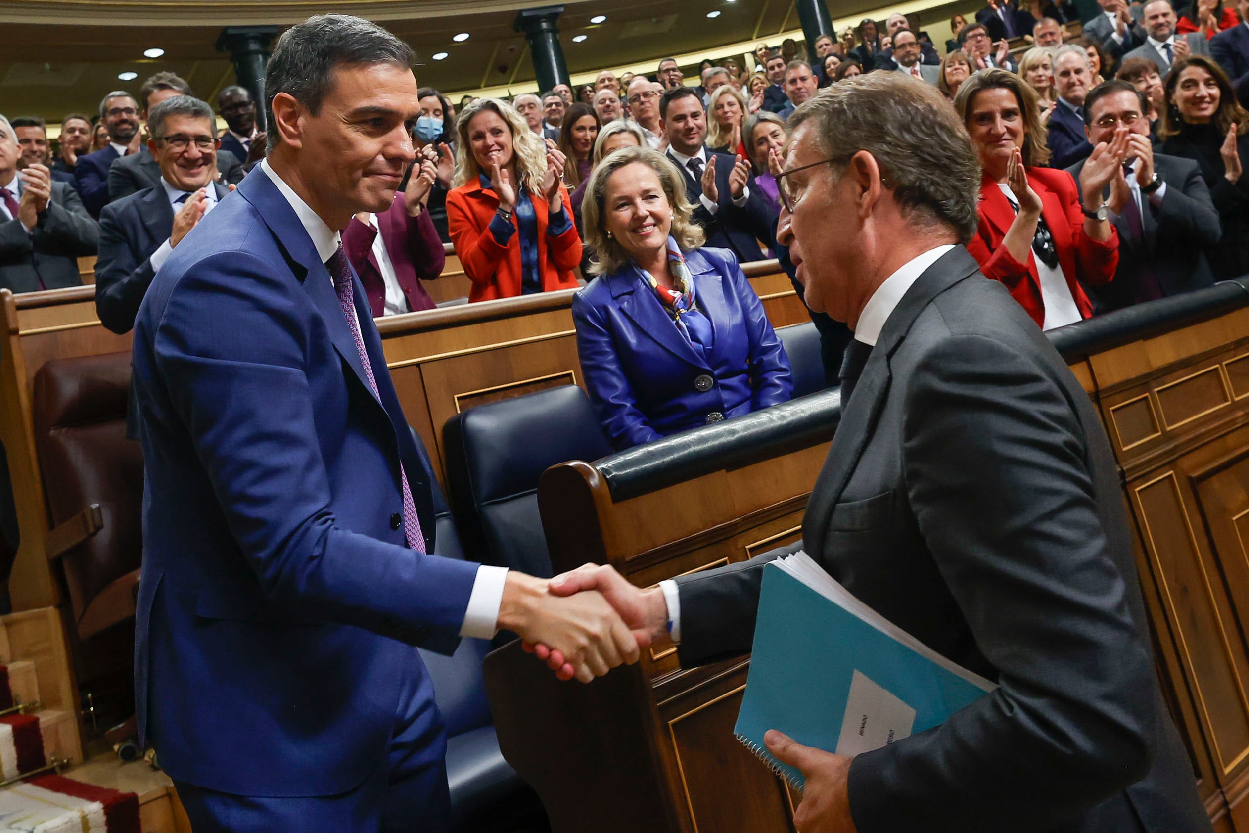 El líder del PP, Alberto Núñez Feijóo (d), felicita al presidente del Gobierno en funciones, Pedro Sánchez, al término de la segunda jornada del debate de investidura. EFE/ Javier Lizón