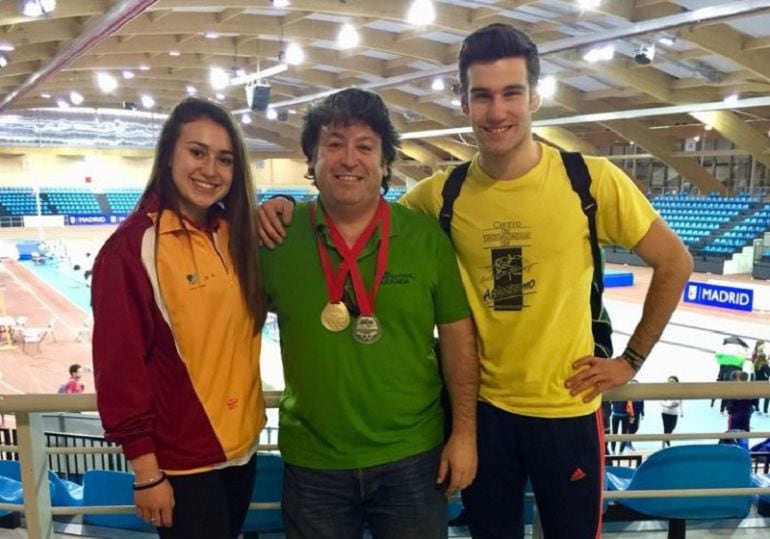 Mara Arranz (i) y Miguel Baños (d), ambos junto a su entrenador Marcos de Miguel (centro) en la pista de Gallur.