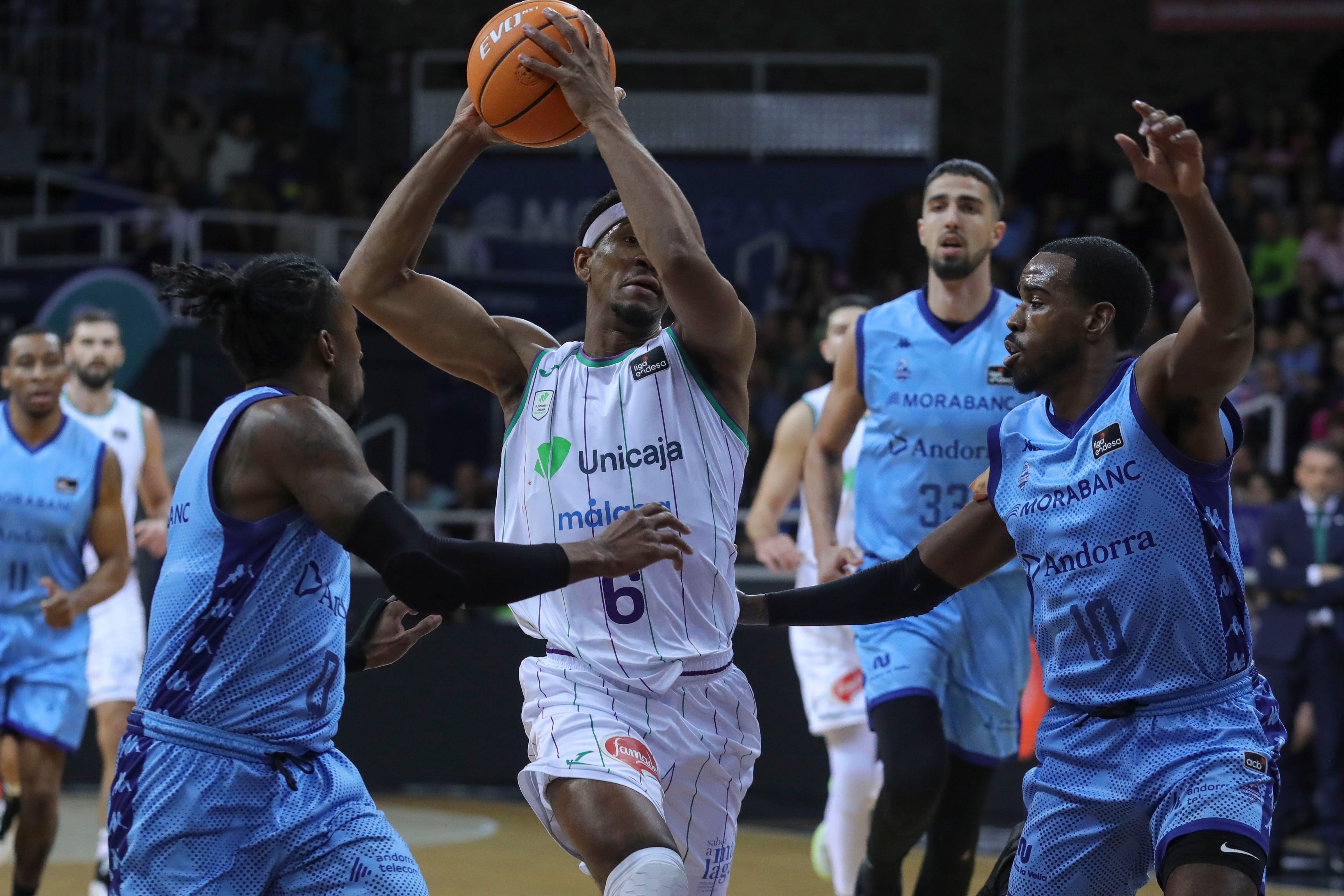 Kameron Taylor (c) , escorta nord-americà de l&#039;Unicaja, es desfà de Shannon Evans i Jerrick Hardin, del MoraBanc, durant el partit de la vuitena jornada de la Lliga Endesa disputat aquest diumenge al polisportiu d&#039;Andorra.