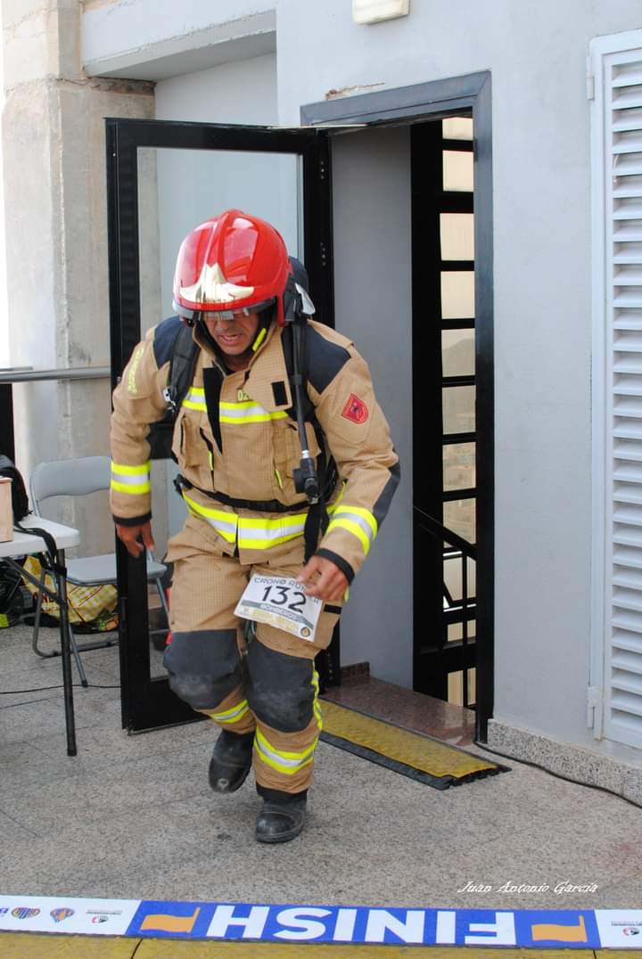 Un bombero con su equipamiento llegando a la meta