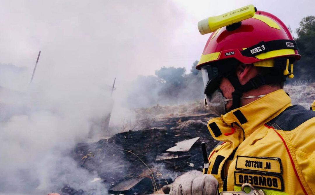 Un bombero apaga el incendio originado en las Faldas del Castillo.