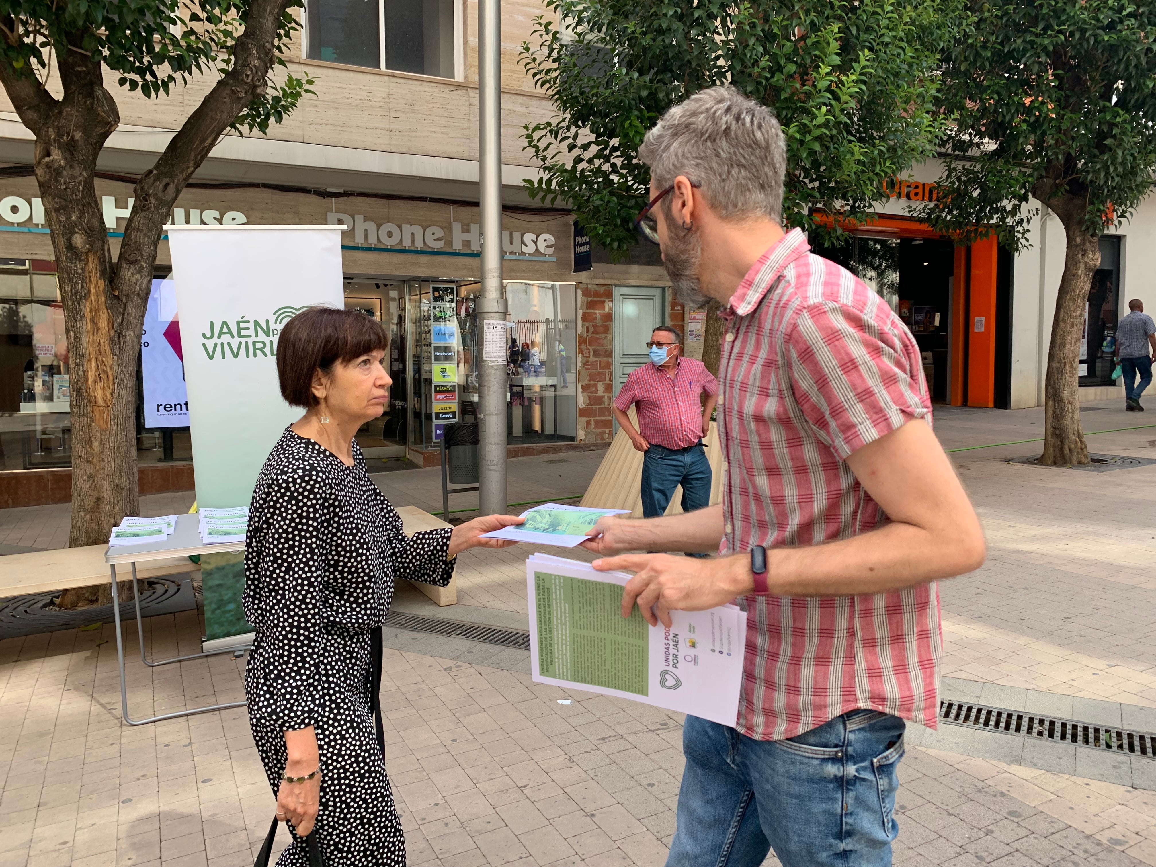 El portavoz municipal de Unidas Podemos en Jaén, Javier Ureña, entrega un díptico a una mujer en la calle Roldán y Marín de Jaén.