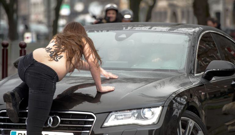 Una activista de FEMEN salta sobre el coche de Dominique Strauss-Kahn a su llegada al juzgado.