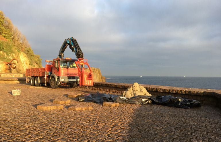 Una grúa trabaja en las obras para reparar el muro de costa del Peine del Viento.