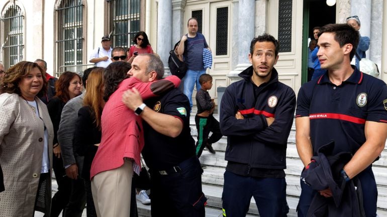 La consejera de Justicia de la Junta de Andalucía, Rosa Aguilar, abraza a Manuel Blanco, ante la presencia de Julio Latorre y José Enrique Rodríguez, los otros dos bomberos de la ONG Proem-Aid que han llegado esta mañana al tribunal de Lesbos, donde se va