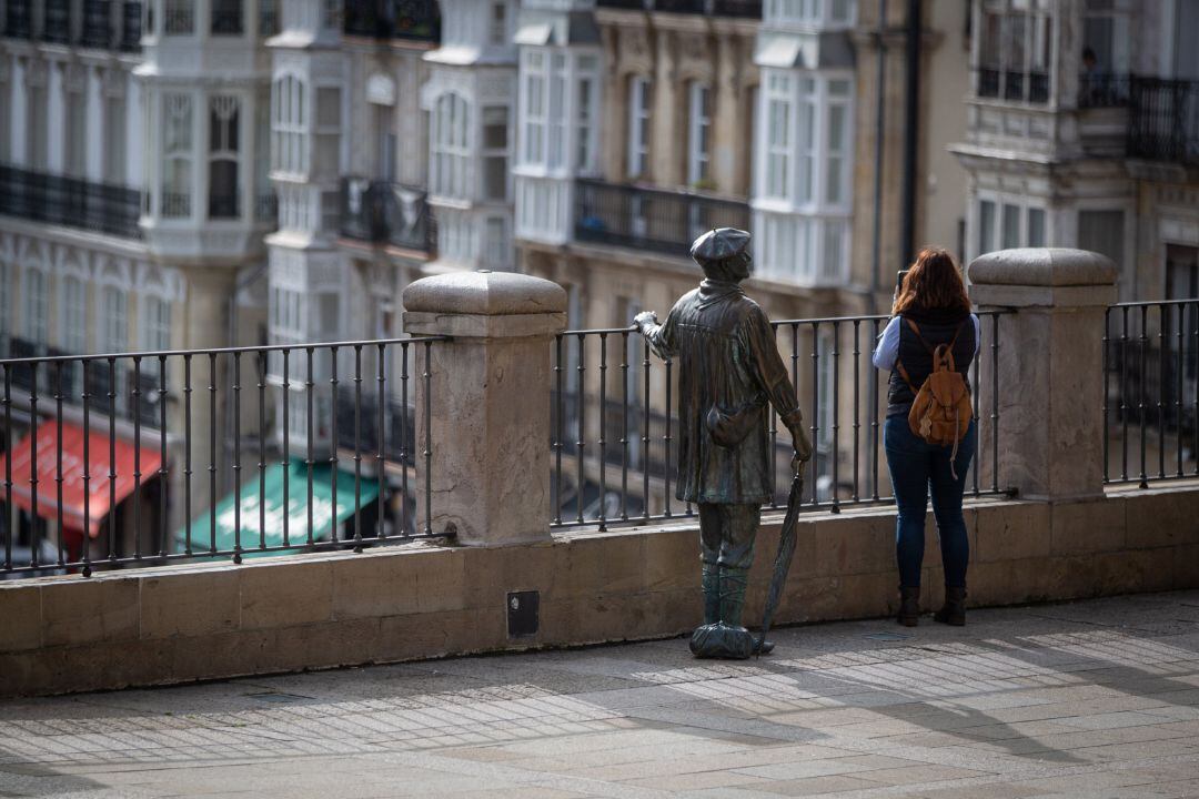 Una mujer realiza una fotografía desde una barandilla del centro de Vitoria 