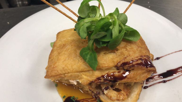 Hojaldre de salmón, queso de cabra y panceta de Soria con jugo de naranja