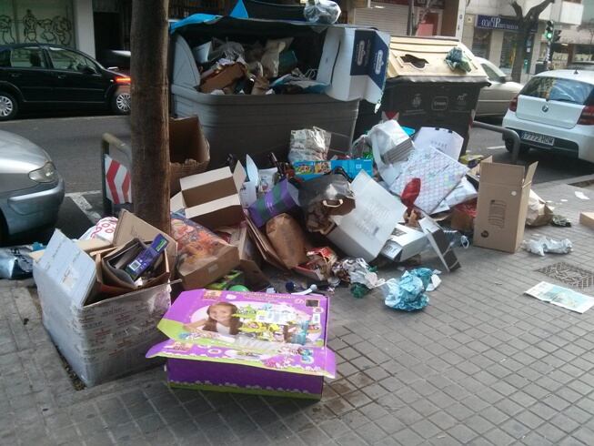 Un contenedor de papel y cartón en la calle Artes Gráficas desbordado por los restos de Reyes