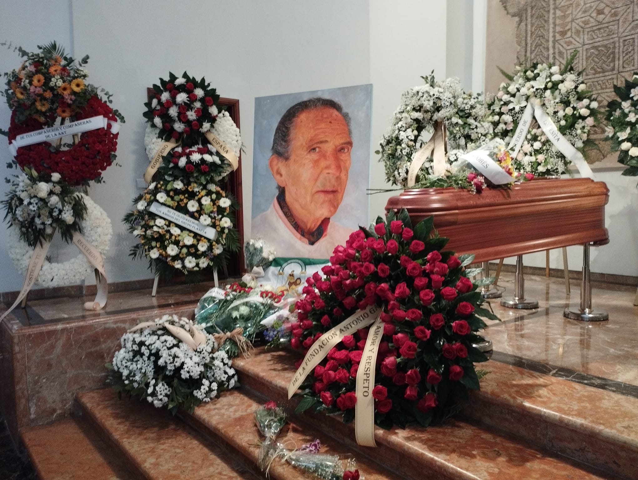 Coronas y ramos de flores junto al féretro de Antonio Gala en la capilla ardiente situada en su fundación.