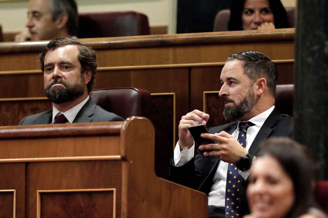 El presidente de Vox, Santiago Abascal (d), y el portavoz Iván Espinosa de los Monteros, durante el debate de investidura, este martes en el Congreso, la segunda jornada del debate del candidato socialista, Pedro Sánchez, en la que se celebra la primera votación, sin que cuente, de momento, con una mayoría suficiente para ser elegido presidente del Gobierno y sin demasiados avances en las negociaciones con Podemos. 