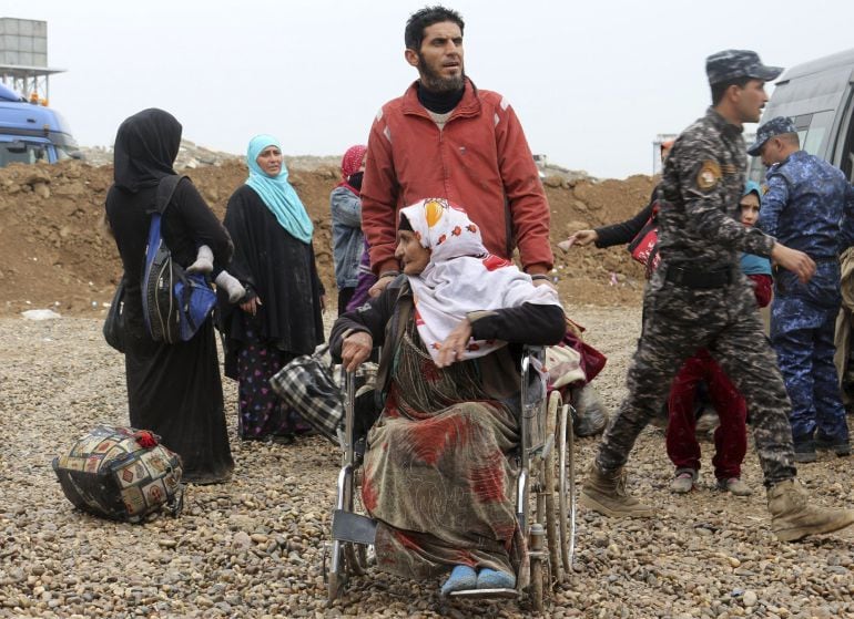 Fotografía que muestra a una familia iraquí desplazada a un campo de refugiados debido al conflicto entre el Ejército de Irak y el Estado Islámico en Hamam Ali, al sur de Mosul (Irak)