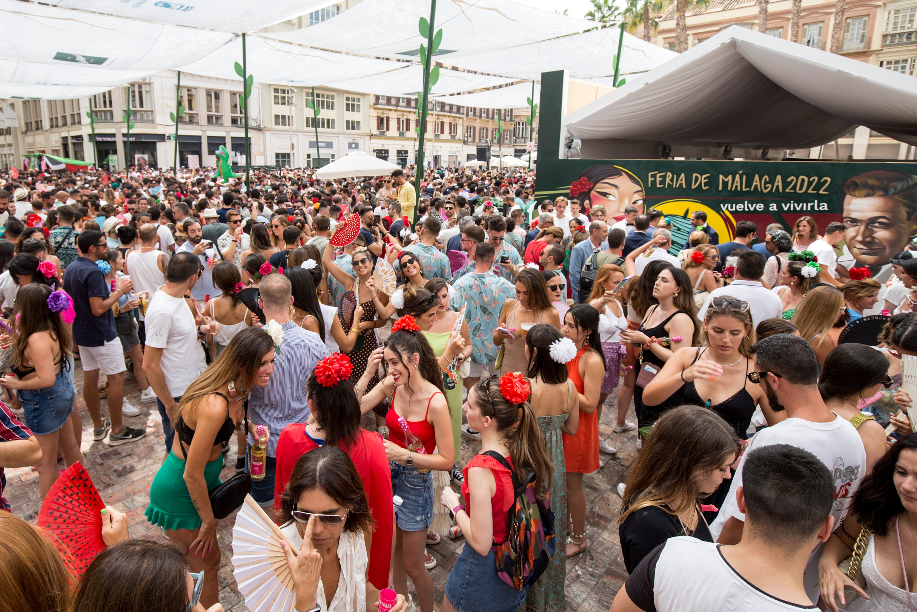 MÁLAGA, 13/08/2022.- Numerosas personas se divierten centro histórico de la ciudad malagueña, donde se celebra parte de la Feria de Málaga, que ha empezado hoy sábado. EFE/ Daniel Pérez
