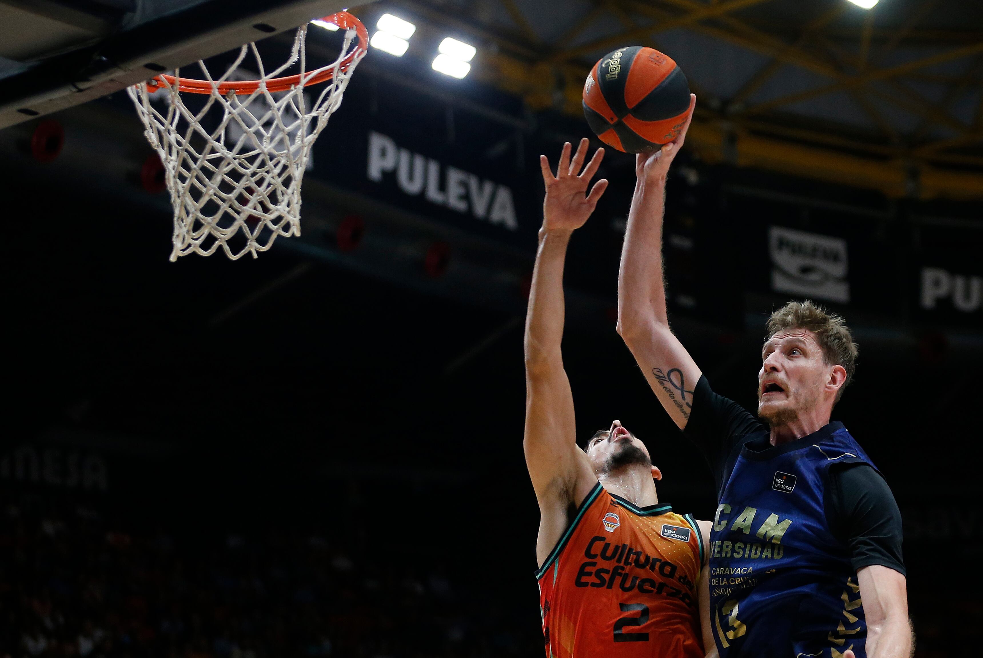 VALENCIA, 16/10/2022.- El alero del Valencia Basket Josep Puerto (i) defiende la entrada a canasta de Artem Pustovyi (d), pívot del UCAM Murcia, durante el partido de la jornada 4 de la Liga Endesa de baloncesto, este domingo en el pabellón de la Fuente de San Luis de Valencia. EFE/ Miguel Ángel Polo
