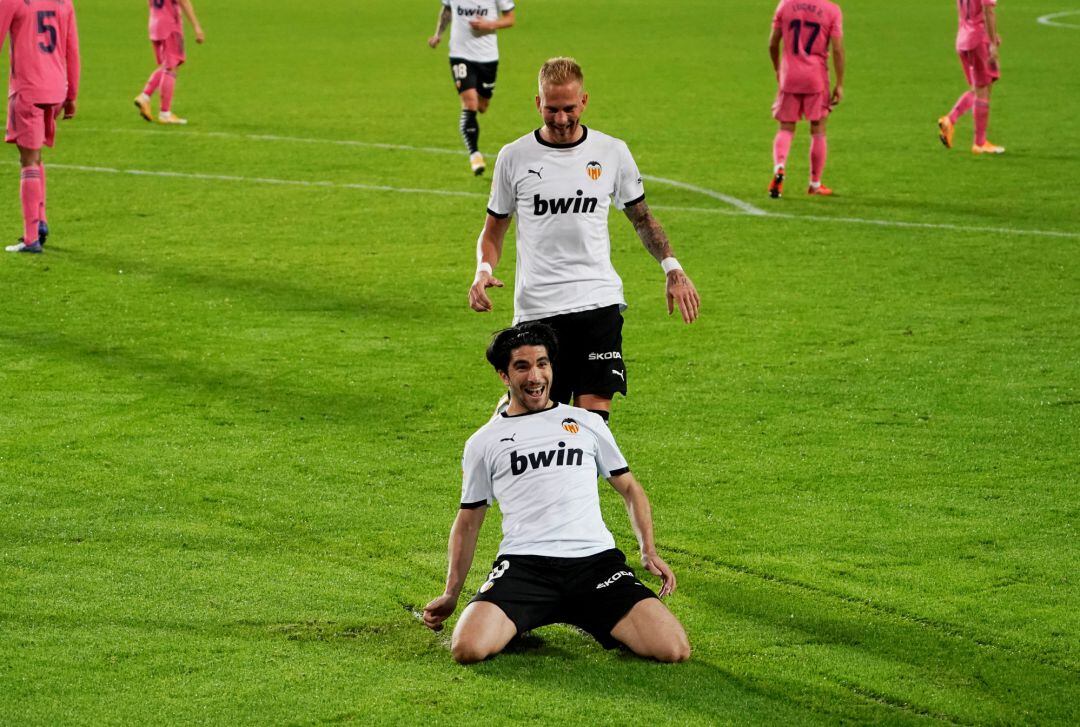 Valencia&#039;s Carlos Soler celebrates scoring their fourth goal and completing his hat-trick with Uros Racic.