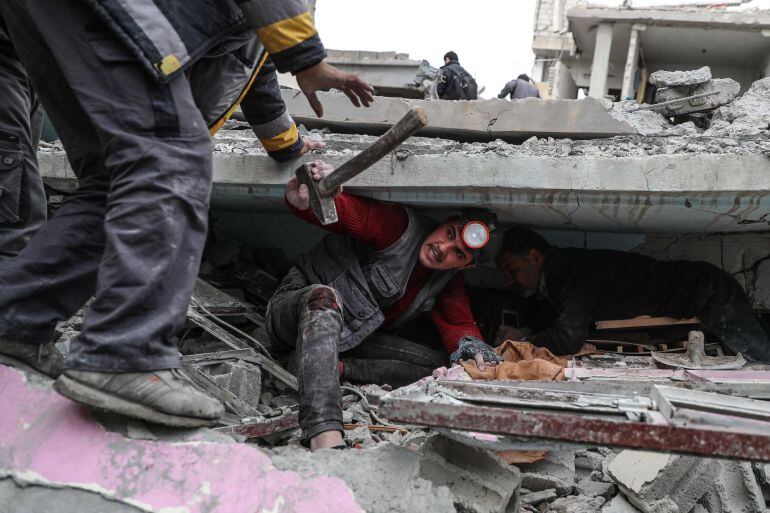 Voluntarios de los Cascos Blancos buscan supervivientes bajo los escombros tras un ataque aéreo en Douma, Siria