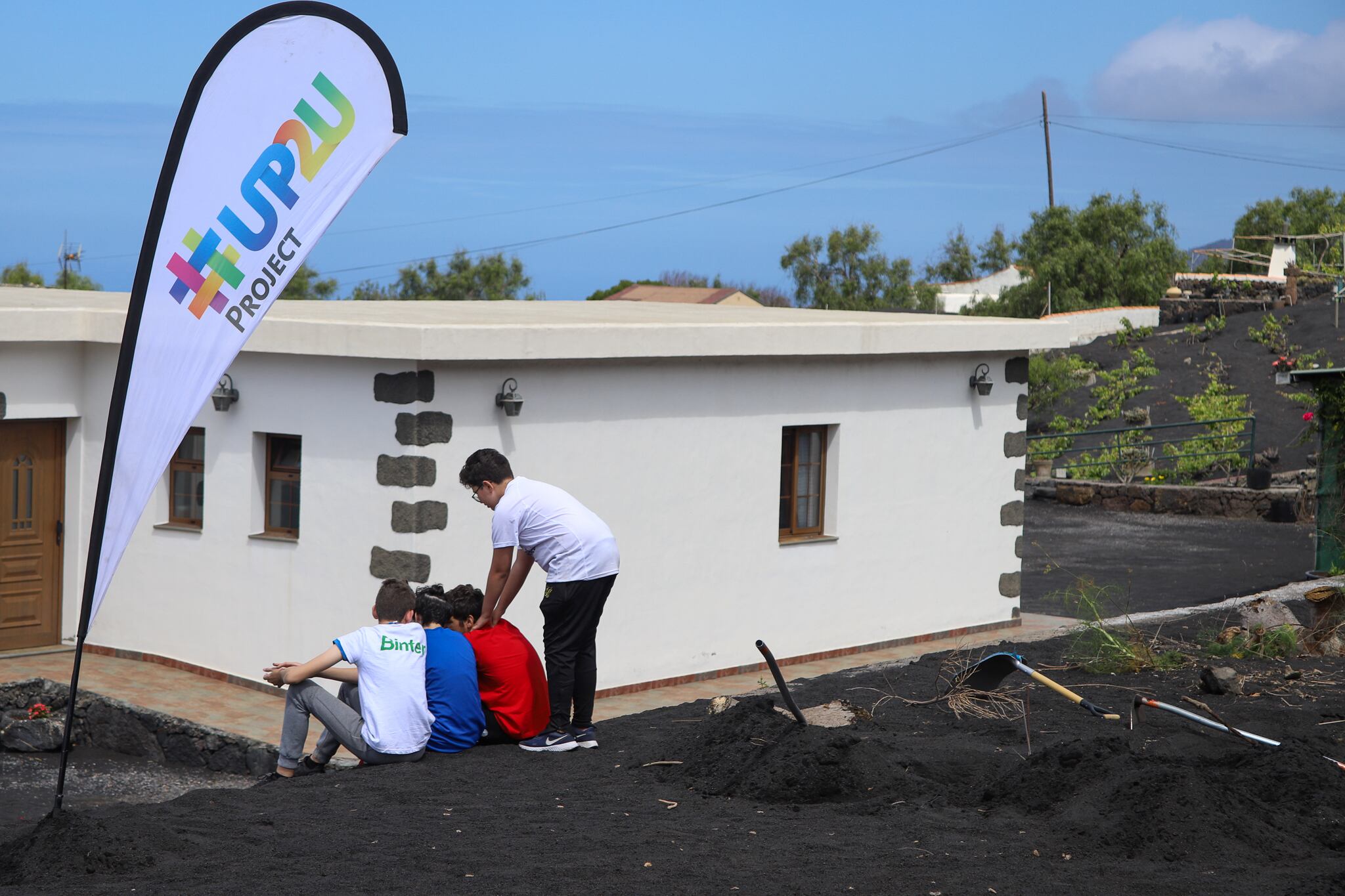 Varios chicos descansan este domingo tras colaborar en la retirada de cenizas de una vivienda en el barrio de Las Manchas, en La Palma, como parte de una iniciativa encuadrada en el Camino de Los Valores de la asociación UP2U