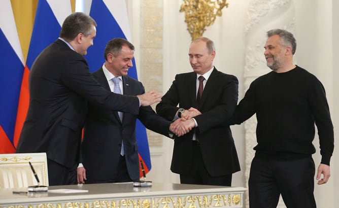 El presidente ruso, Vladímir Putin (2d), une sus manos al primer ministro de Crimea, Serguéi Axiónov (izda), al presidente del Parlamento de Crimea, Vladimir Konstantinov, y al jefe de la administración de Sebastópol, Alexei Chaliy (dcha)