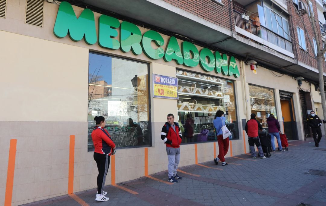 Varias personas esperan para poder entrar a comprar en un supermercado Mercadona.