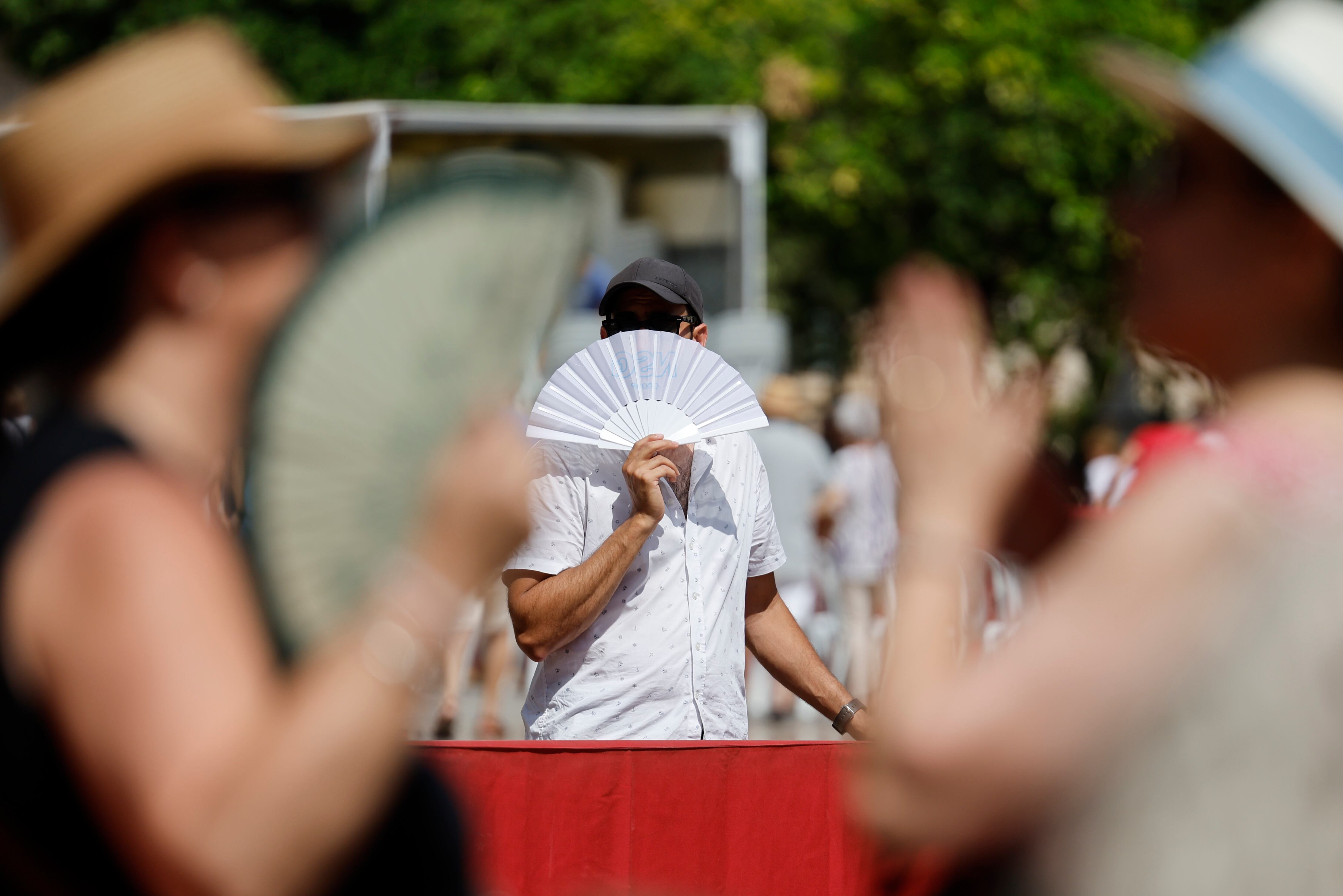 Un viandante se abanica para combatir el calor mientras pasea por Valencia la semana pasada.