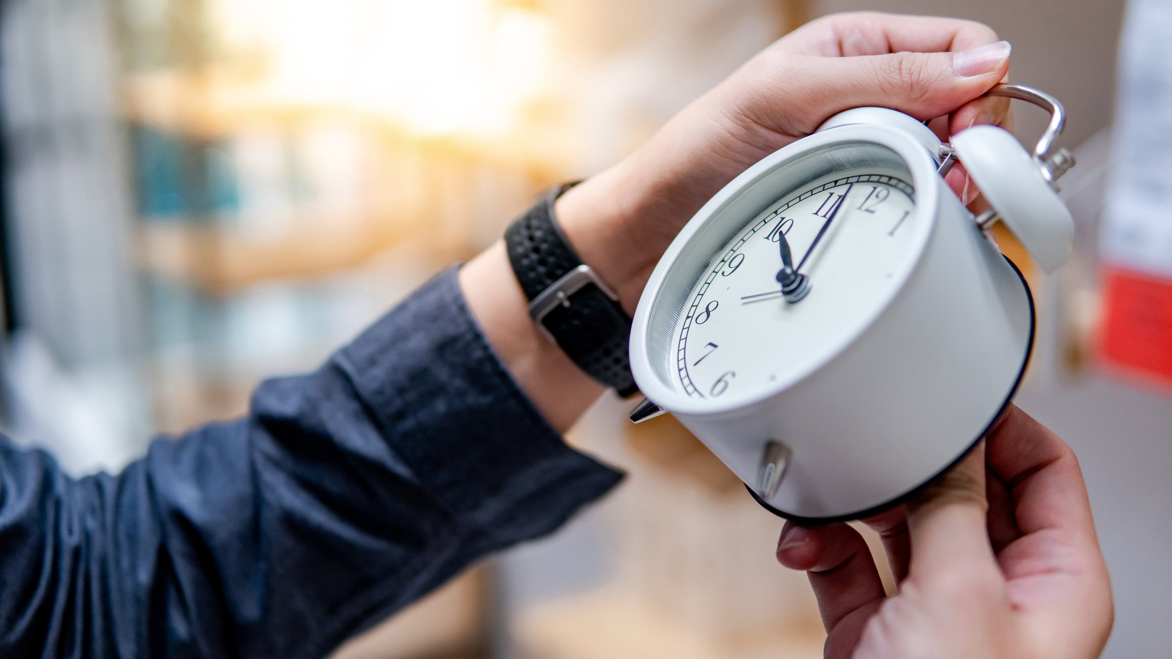 Un hombre cambia la hora en su reloj.