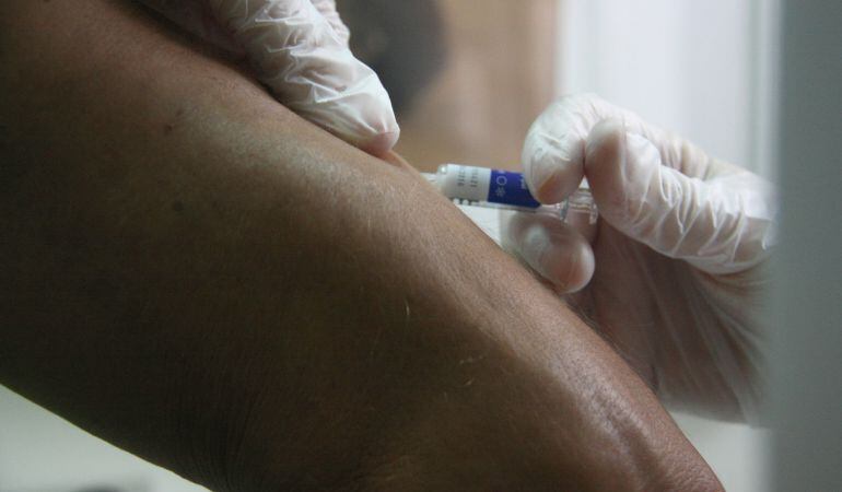 Pla detall d'una infermera vacunant de grip un pacient, el primer dia de campanya el 19 d'octubre de 2015