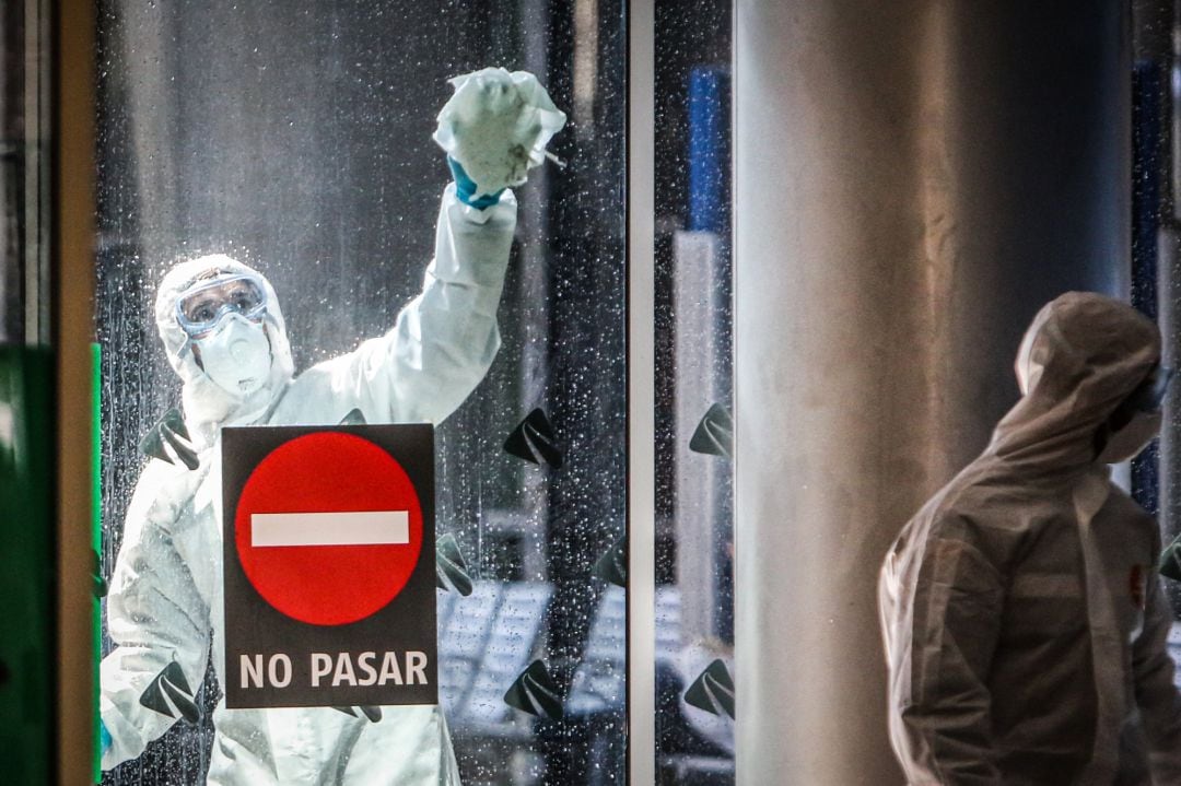 Members of the Spanish Military Emergency Unit (UME) wear protective suits as they conduct disinfection works at the Malaga