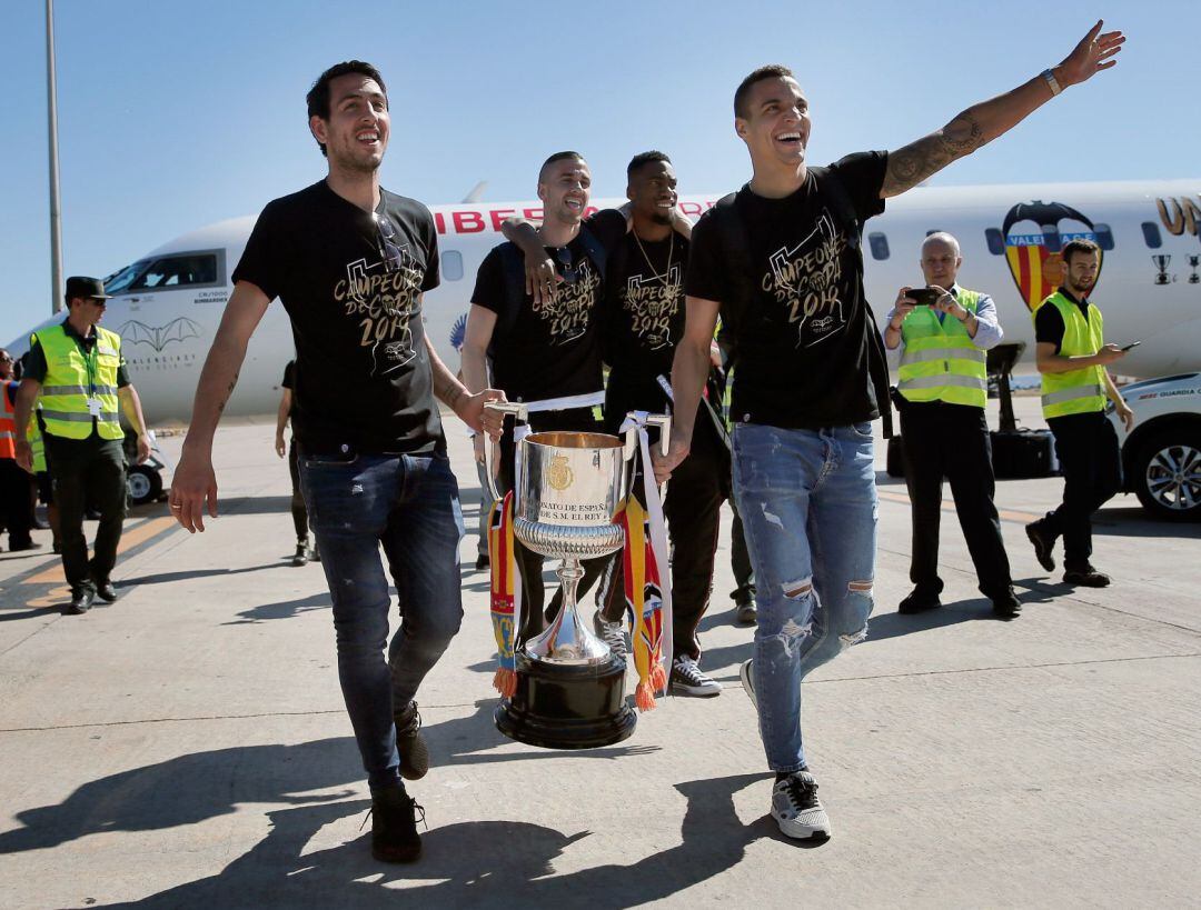 El capitán del Valencia CF, Dani Parejo y su compañero Rodrigo bajan por la escalerilla del avión con la Copa de Rey 