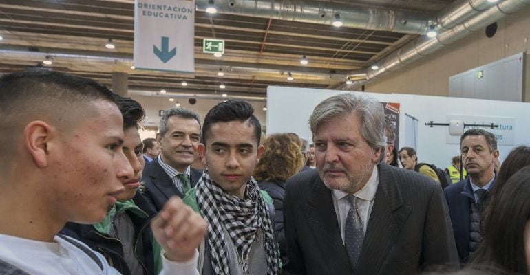 El ministro de Educación, Íñigo Méndez de Vigo, conversa con unos estudiantes durante la visita que ha realizado en Ifema a los pabellones dedicados a la Feria educativa AULA. 