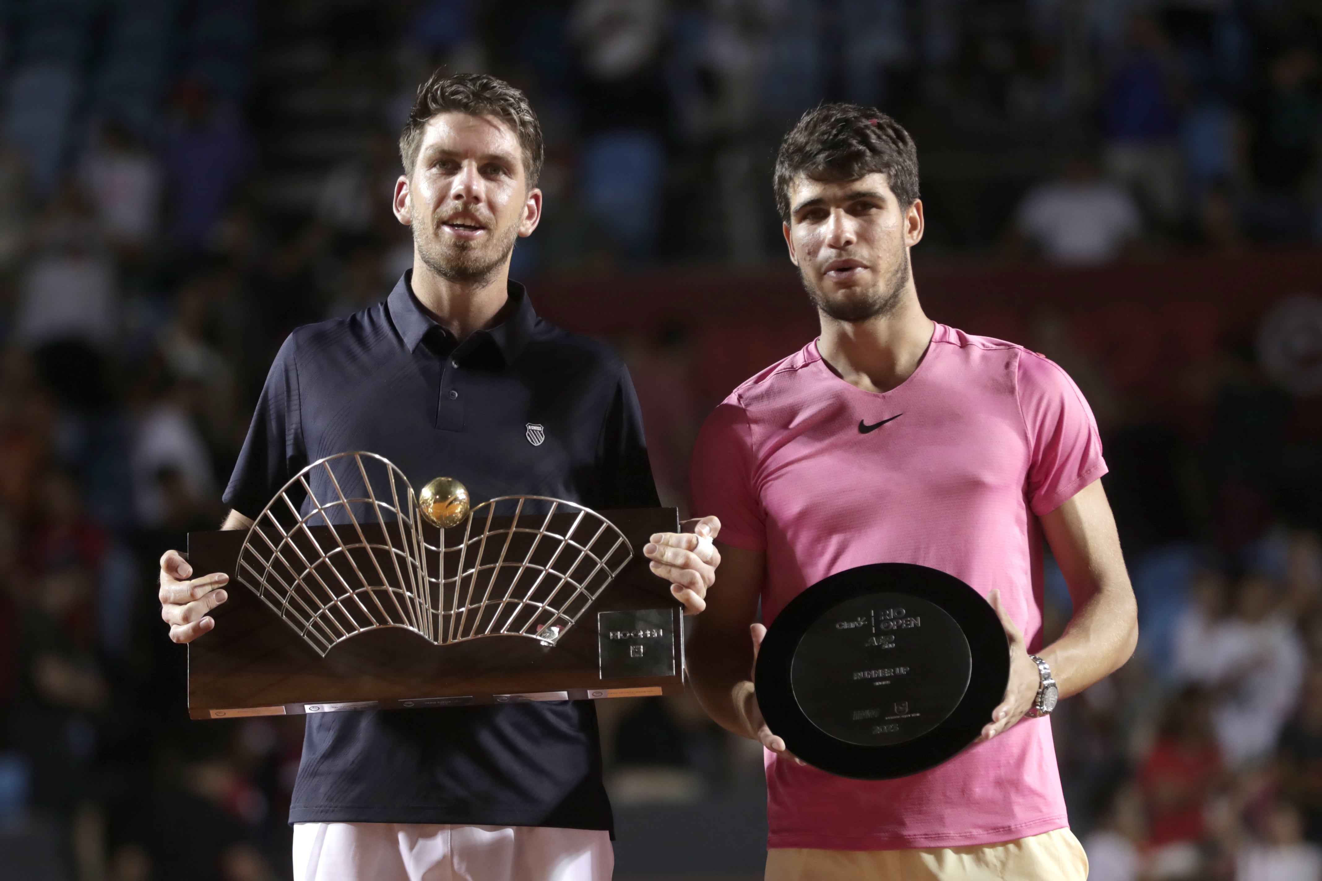 El británico Cameron Norrie (i) celebra con el trofeo de ganador junto al tenista español Carlos Alcaraz durante el partido de la final del Abierto de tenis de Río.