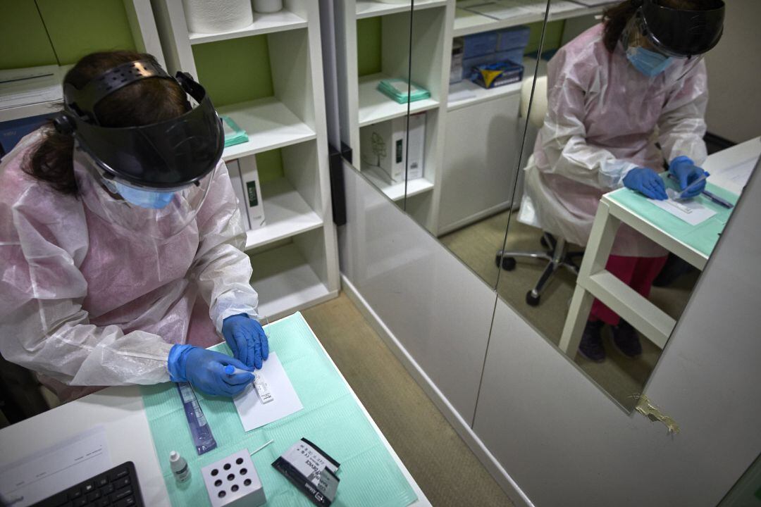 Una farmacéutica comprueba si la persona a la que le ha realizado el test de antígenos es positiva o negativa por Covid-19