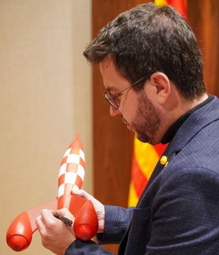 Pere Aragonès firma el objeto que cede para &#039;Cap nen sense joguina&#039;, el cohete de &#039;De la tierra a la luna&#039; de Tintín