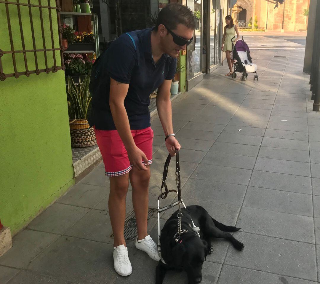 Isidro Sánchez junto con su perra guía en la Plaza de España de Valdepeñas (Ciudad Real) 