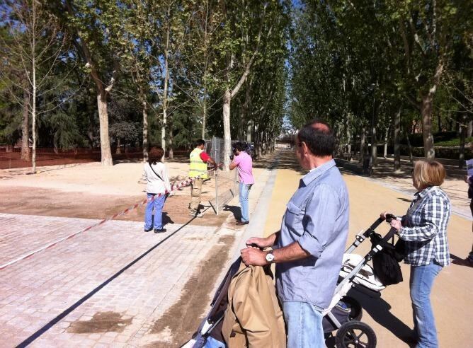 Los primeros madrileños que han entrado en el nuevo parque de Madrid, esperando a que los operarios retiraran la cinta