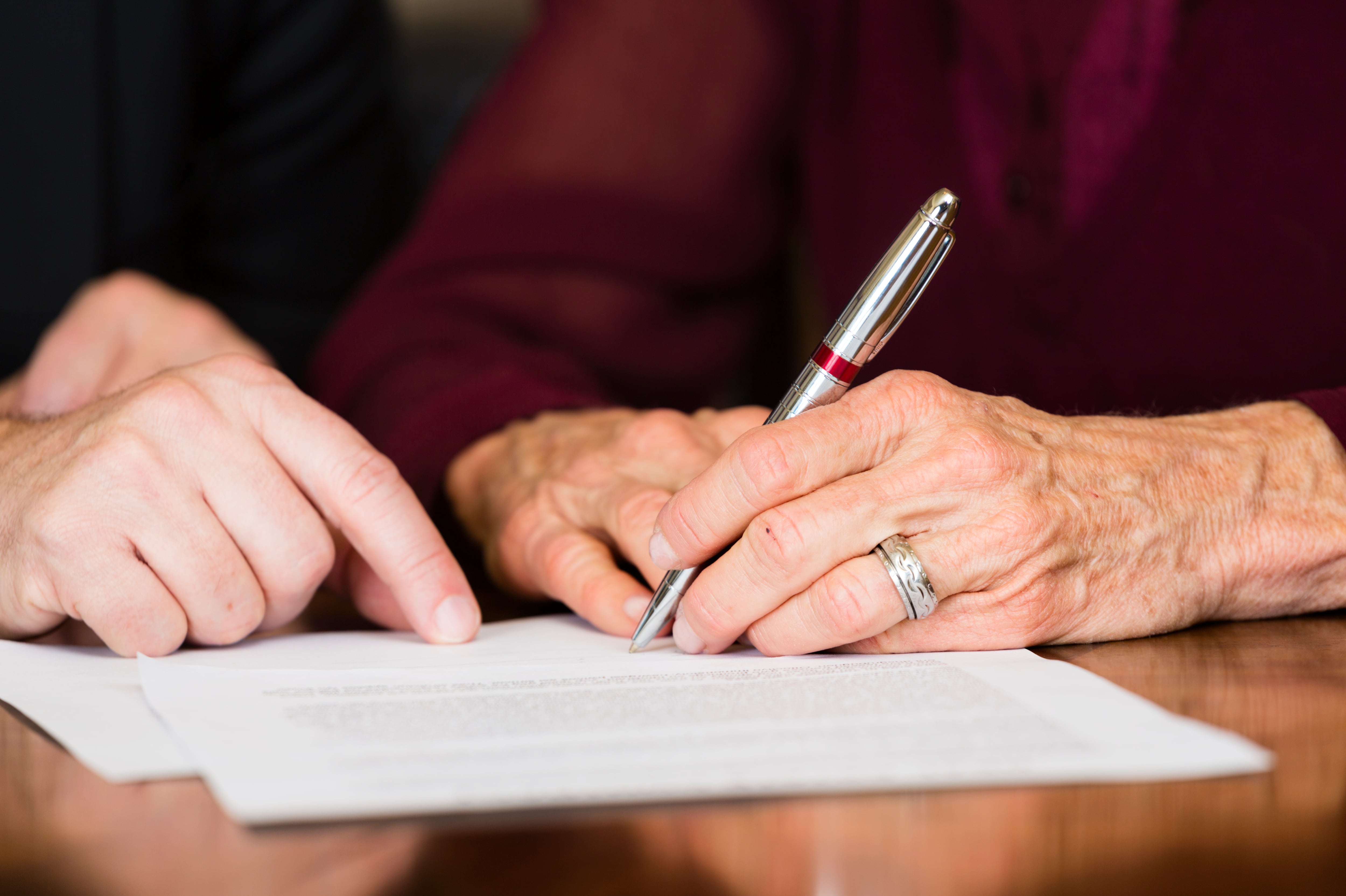 Una mujer firma su testamento