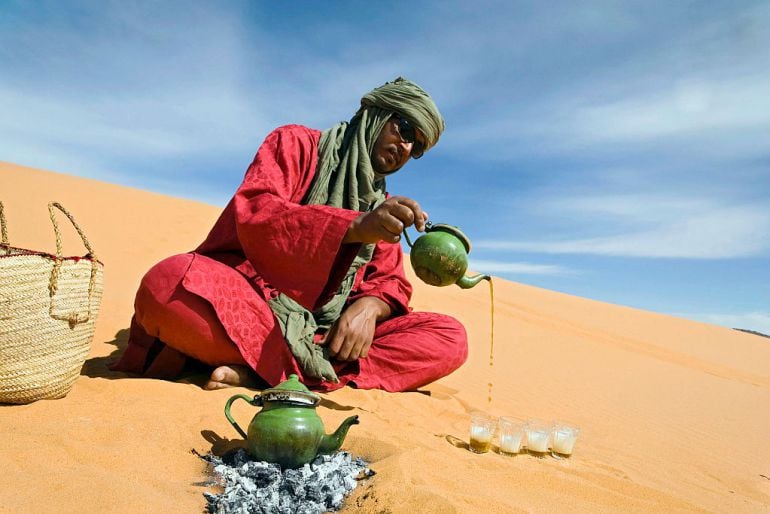 Un tuareg preprando té sobre la arena del Desierto del Sahara, en Tassili n&#039;Ajjer (Algeria).