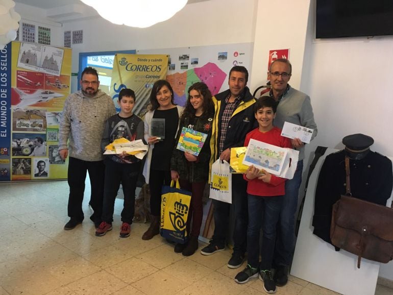 Juan González posa con los sellos conmemorativos de Nigrán y alumnos del Carlos Casares participantes en el concurso