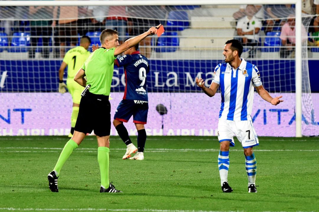 - El árbitro Iglesias Villanueva (i) muestra la tarjeta roja a Juanmi, de la Real Sociedad, durante el partido ante el Huescaen el estadio de El Alcoraz.