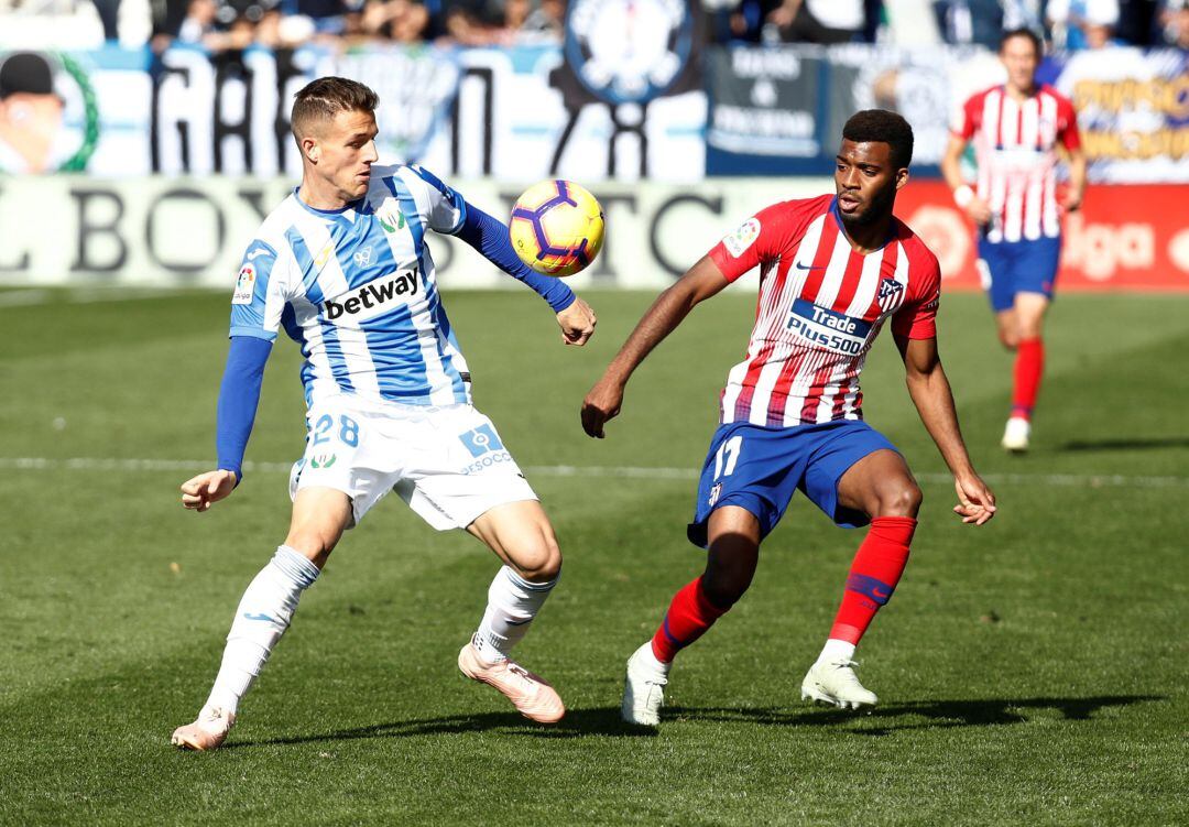 Rodrigo Tarin (i) ante Thomas Lemar  en el derbi C.D. Leganés- C.Atletico de Madrid en Butarque.