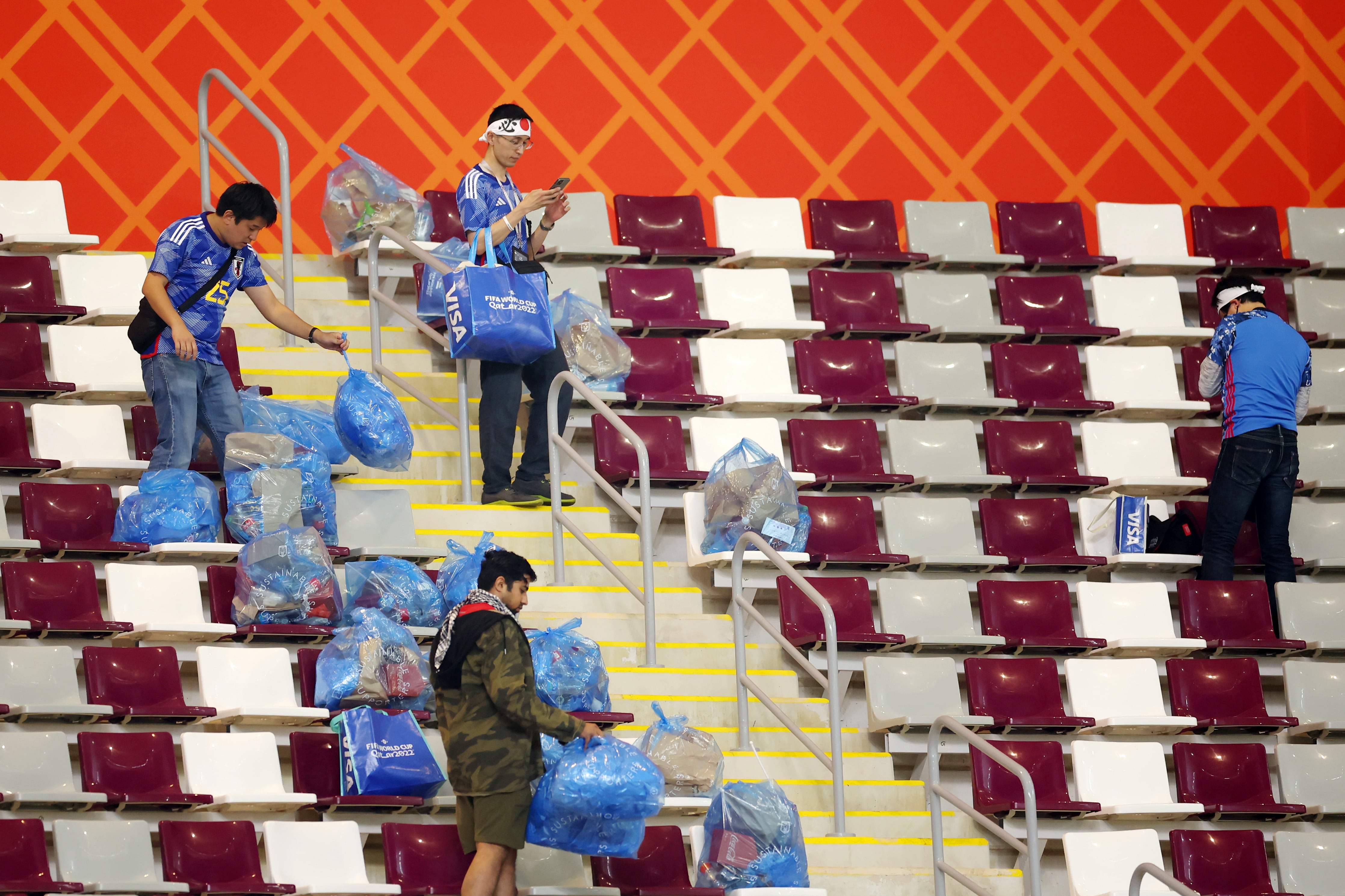 Aficionados japoneses limpiando el Estadio Internacional Khalifa de Doha