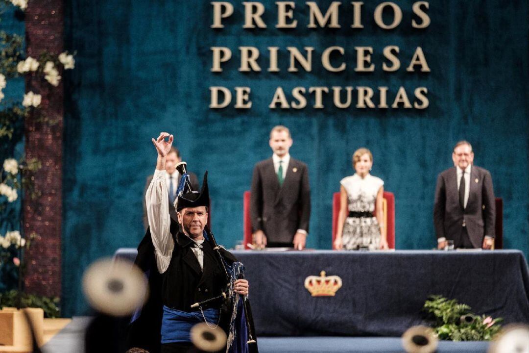 Guti dirige a la Real Banda de Gaitas Ciudad de Oviedo durante la ceremonía de 2017 en el Campoamor, con los reyes al fondo