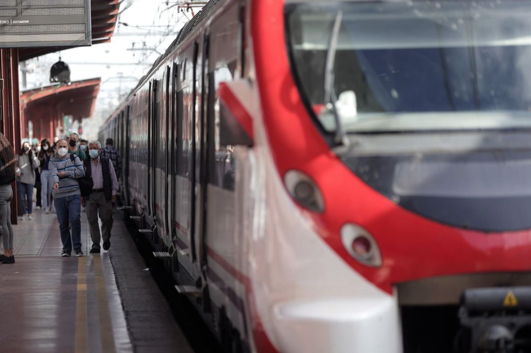 Varios pasajeros esperan en uno de los andenes de la estación 