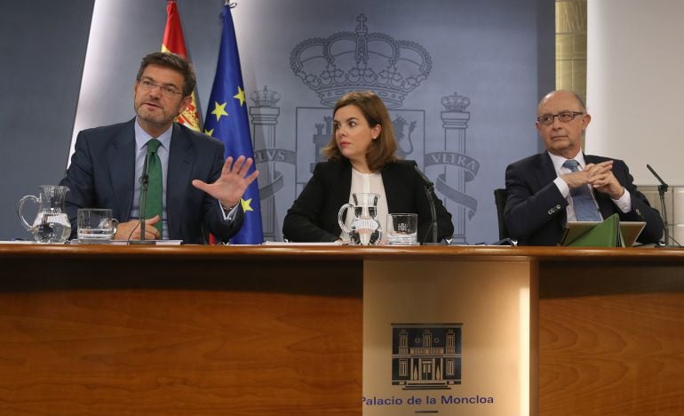 Soraya Sáenz de Santamaría, Rafael Catalá y Cristóbal Montoro, durante la rueda de prensa posterior al Consejo de Ministros