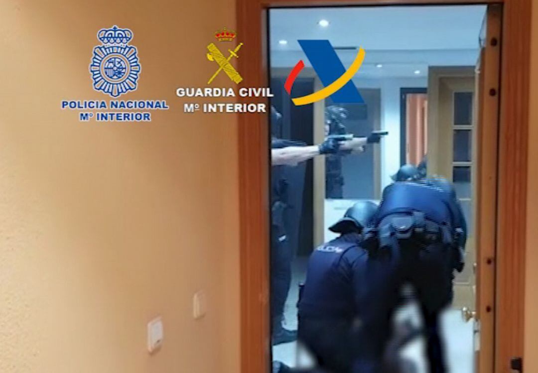 Los agentes entran en una de las viviendas intervenidas