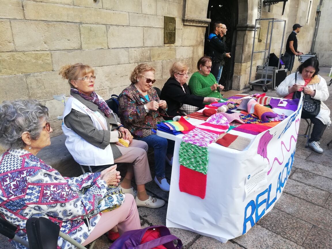 Algunes de les dones grans voluntàries i altres, que reben els serveis de voluntariat de Creu Roja, teixint una manta totes juntes ahir a la plaça Paeria, on es va presentar el programa Sempre Acompanyats.