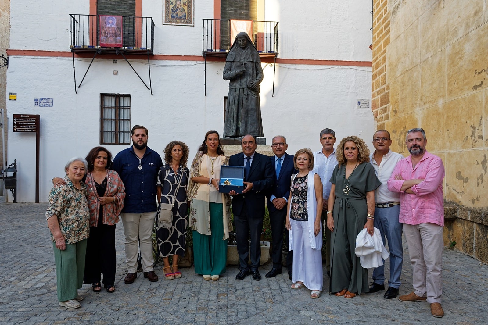 Foto de familia ante el monumento a santa Ángela de la Cruz que se encuentra junto a la Iglesia Prioral de Santa María en Carmona