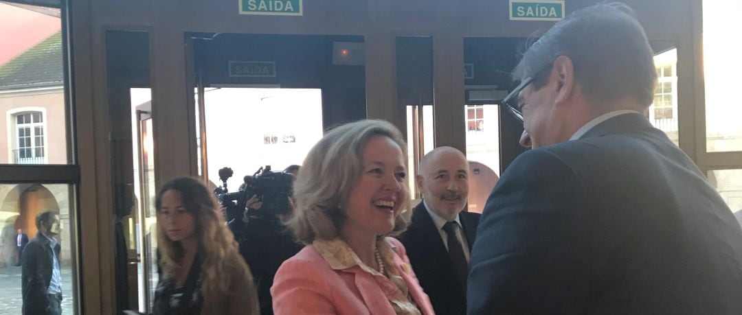 Nadia Calviño saluda a Julio Abalde ante la atenta mirada de Javier Losada