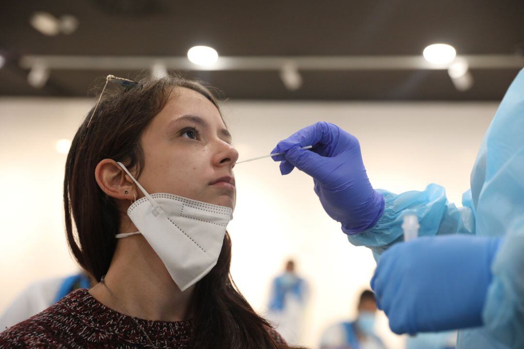 Una trabajadora sanitaria le realiza un test de antígenos a una joven