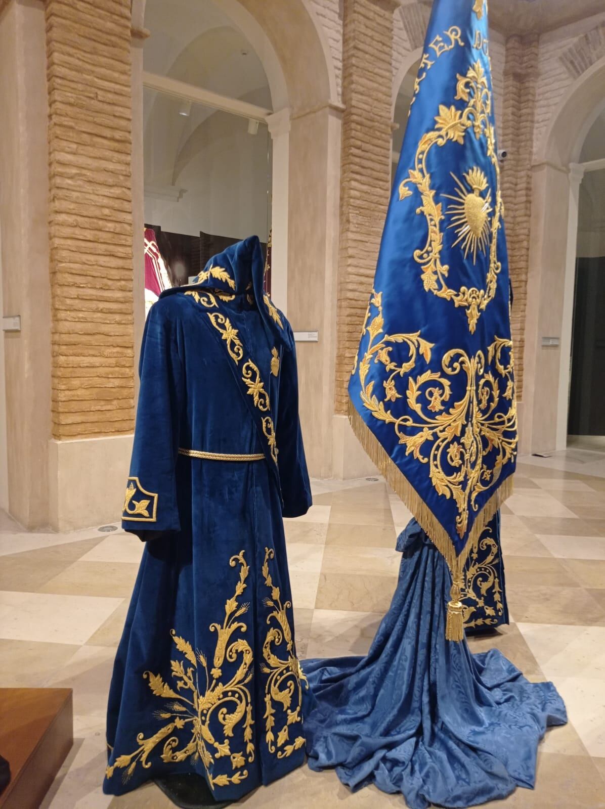 Traje de mayordomo junto a la nueva bandera del Paso Azul